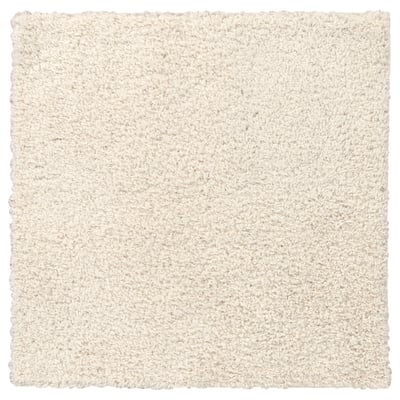 A white, soft, square rug with shaggy texture, made from polypropylene and synthetic rubber for a comfortable feel.