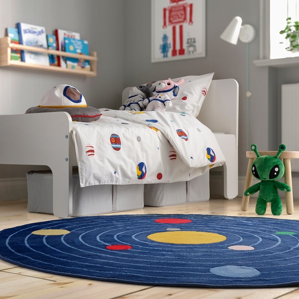 Childs space-themed bedroom with AFTONSPARV duvet, bookshelf, and alien toy.