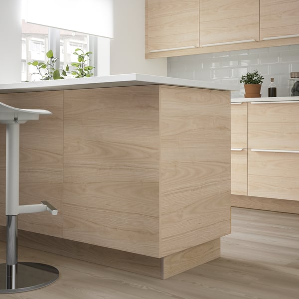 ASKERSUND cabinets, modern design, sleek, natural wood, fits under island, holds plant, near stool.