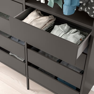 Grey AURDAL dresser with open drawers, neatly folded clothes; ideal for closet storage.