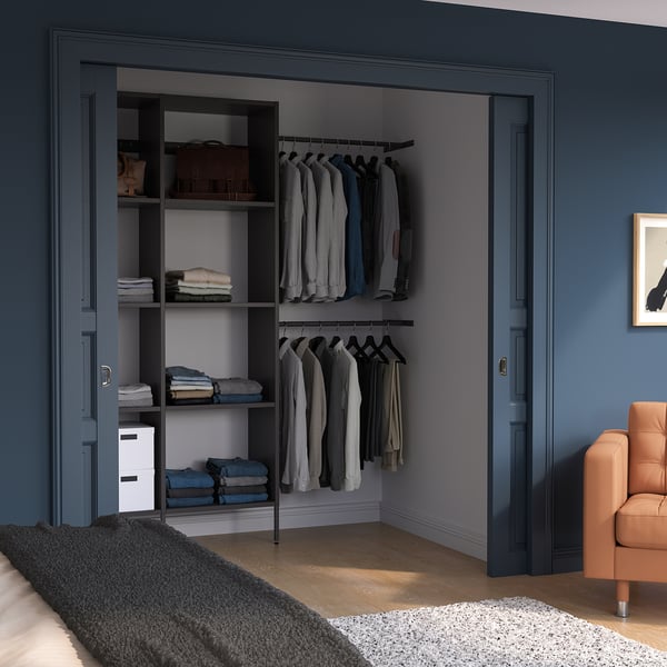 Closet with AURDAL shelves & hangers. Chair, rug, blue-gray room.