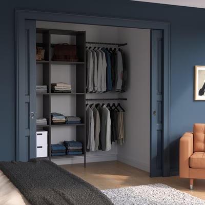 Closet with AURDAL shelves & hangers. Chair, rug, blue-gray room.