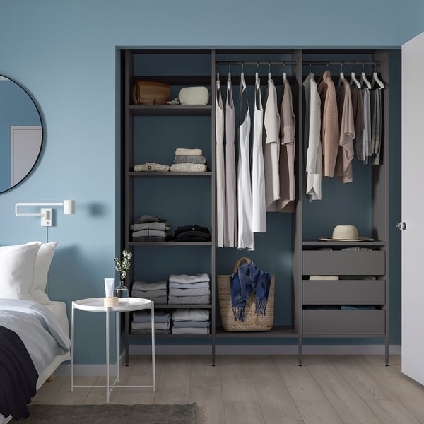 Modern grey wardrobe with clothes & plant side table.