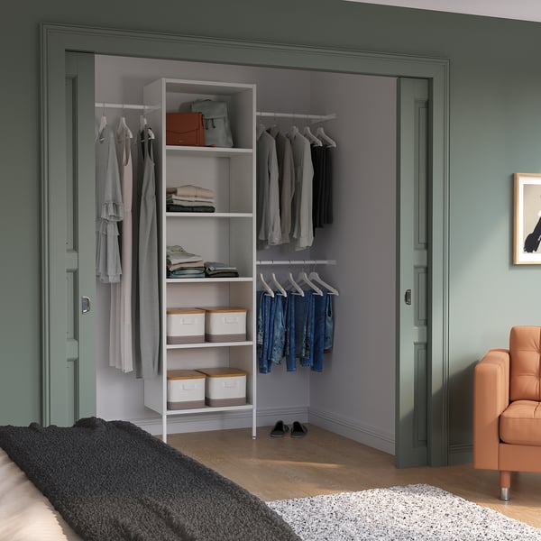 White AURDAL storage in bedroom with clothes & boxes, near chair & rug.
