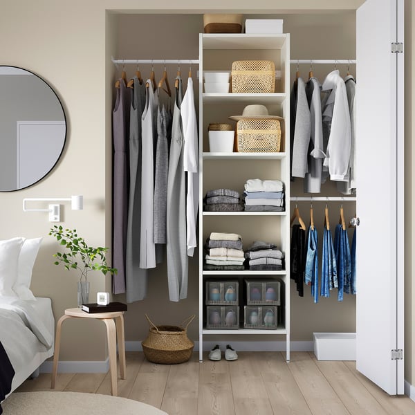 Minimalist closet with AURDAL units, neatly organised clothes, plant, and mirror.