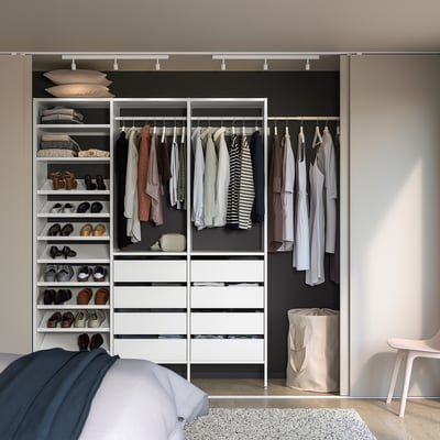 Organised walk-in closet with AURDAL shelves and chair.