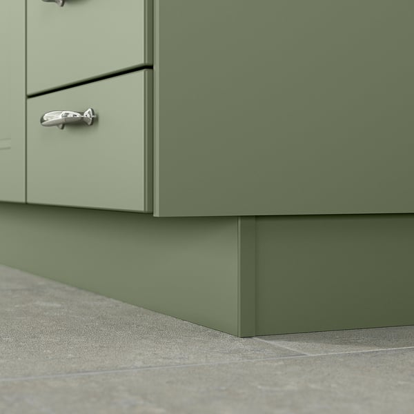 A green kitchen cabinet base with a matching plinth, made of plastic and thermoplastic elastomer, featuring a matte finish and modern design.