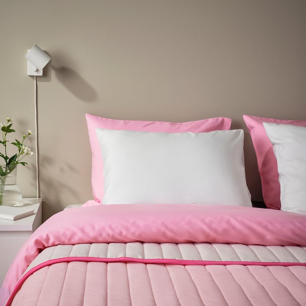 Pink BÄRGLIM pillowcases on bed. Super soft, white recycled polyester, rectangular.