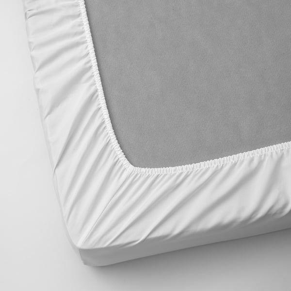 Fitted sheet with elastic edges, covering a thick mattress, showcasing its soft surface.