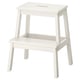 A white BEKVÄM step stool with a rectangular top and four angled legs, made from solid rubberwood.