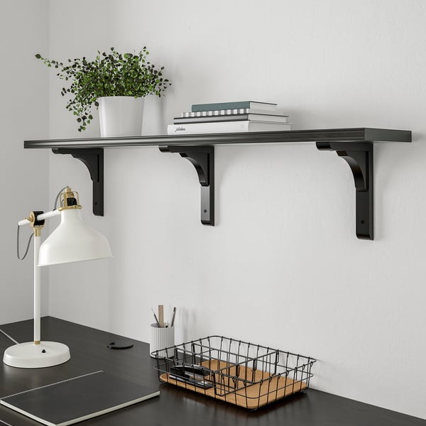 Black BERGSHULT shelf with books & plant, desk with lamp & basket.