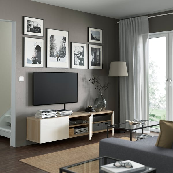 Modern living room with BESTÅ tv bench, cable management, and soft-close drawers. Mounted tv, decorative art, and floor lamp.