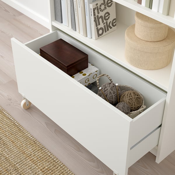 Open BILLY drawer revealing hidden storage with simple, eco-friendly basket and wooden box inside.