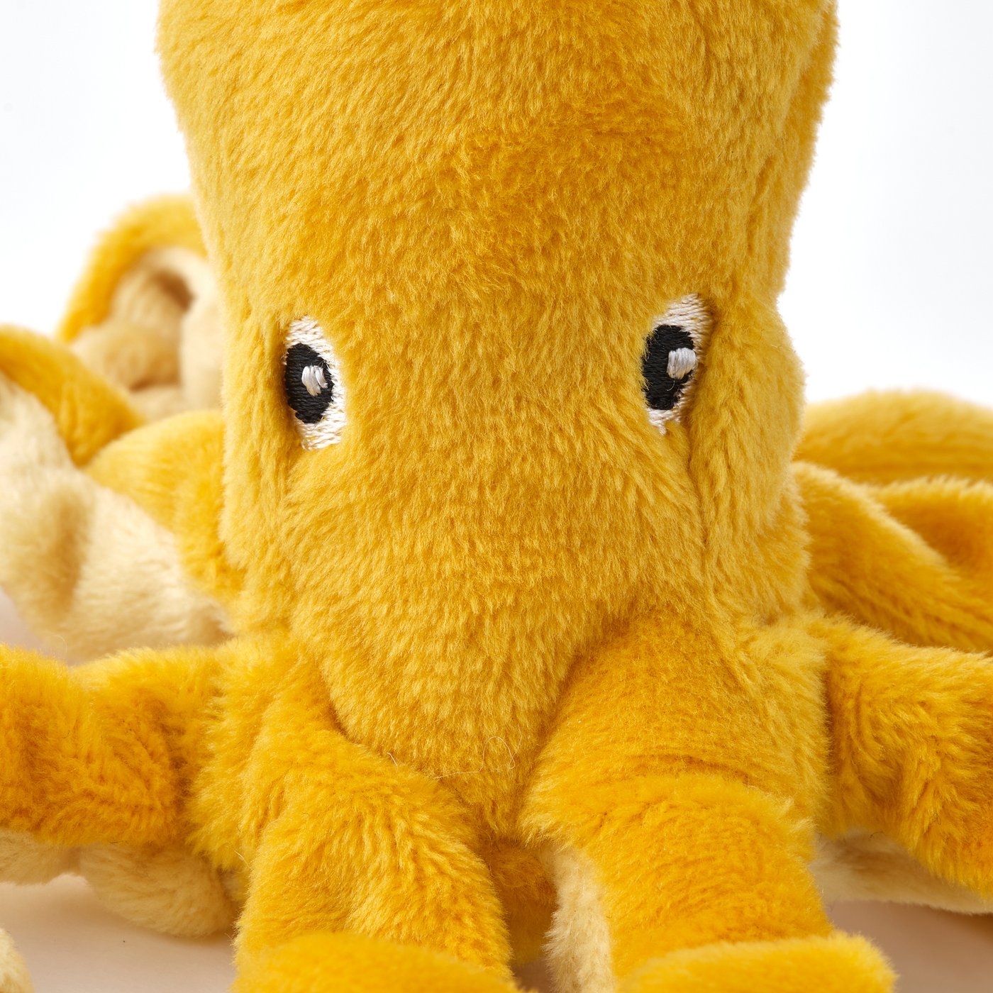 Cuddly cuddly toy octopus, bright yellow, with embroidered eyes and soft texture, perfectly crafted for comfort and durability.