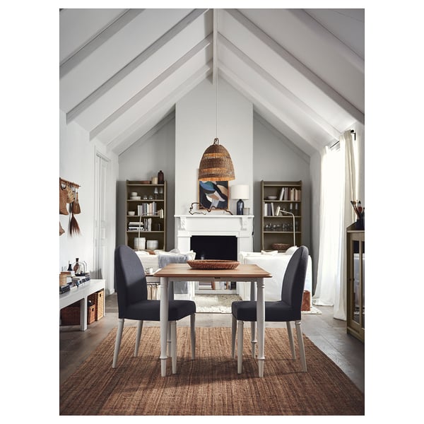 Modern dining room with DANDERYD rectangular table, four grey chairs, white fireplace, and large windows.