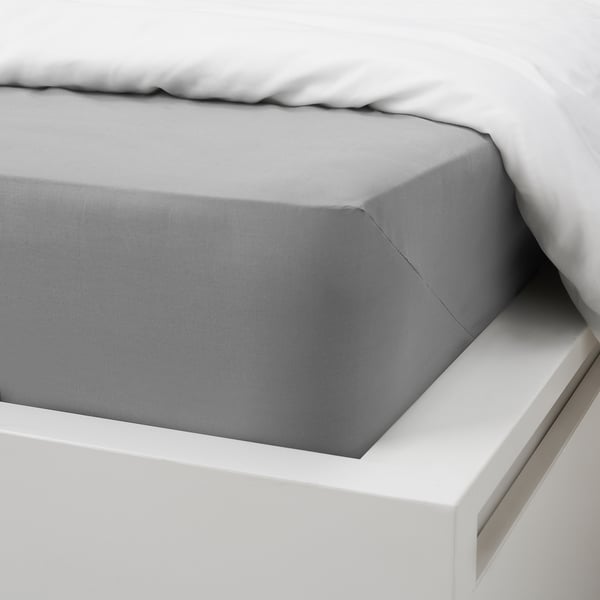 Grey cotton bed sheet set. Includes flat and fitted sheets, shown on white bed.