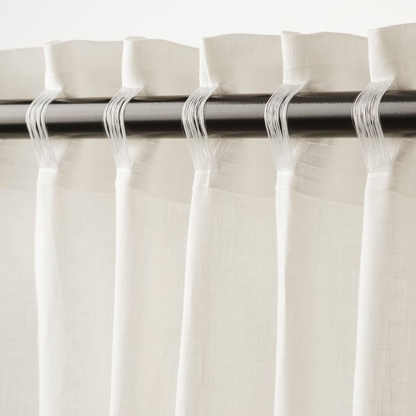 Curtains with loops for hanging. These white linen curtains offer privacy and let light through.