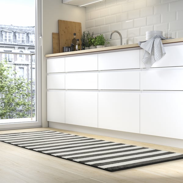 Striped ELSYSTEM rug in modern kitchen, near cabinets and window, contrasting with wood floor.