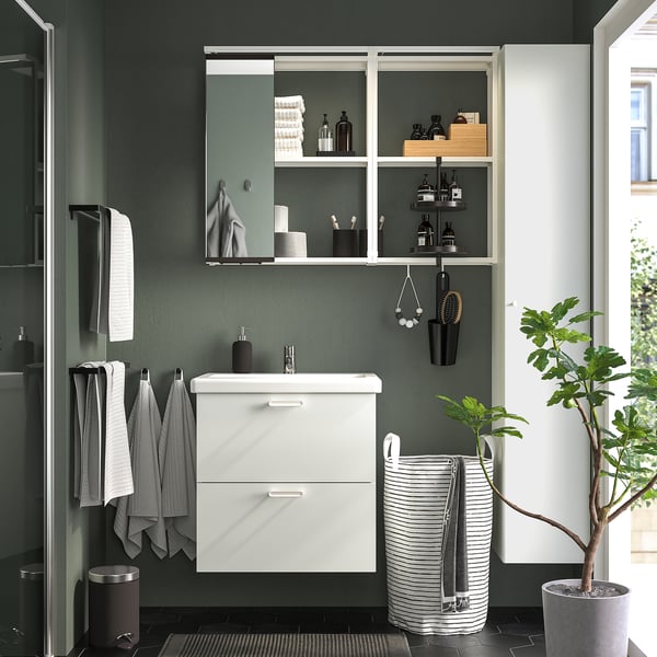 Modern bathroom with ENHET white storage, mirror, towels, toiletries, plants, and hooks.