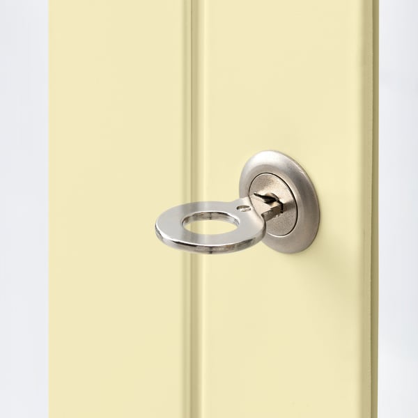Close-up of cream-colored glass cabinet door with open circular latch lock, showing silver handle.
