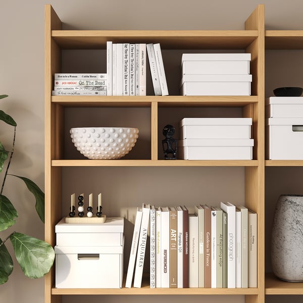 Wooden shelves with books, boxes, bowl, and statue.