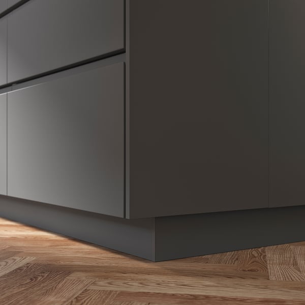 Grey FÖRBÄTTRA kitchen cabinet plinth on wooden floor.