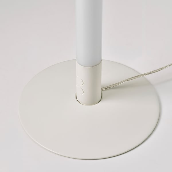 Base of a sleek modern lamp, likely floor-standing, with minimalist design. White colour, smooth finish, and a centre column. Cable neatly managed.