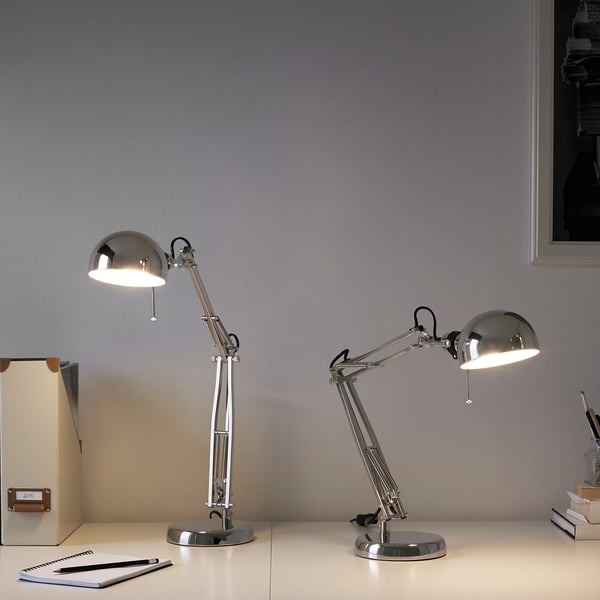 Two adjustable FORSÅ lamps on desk, with notepad and pen.