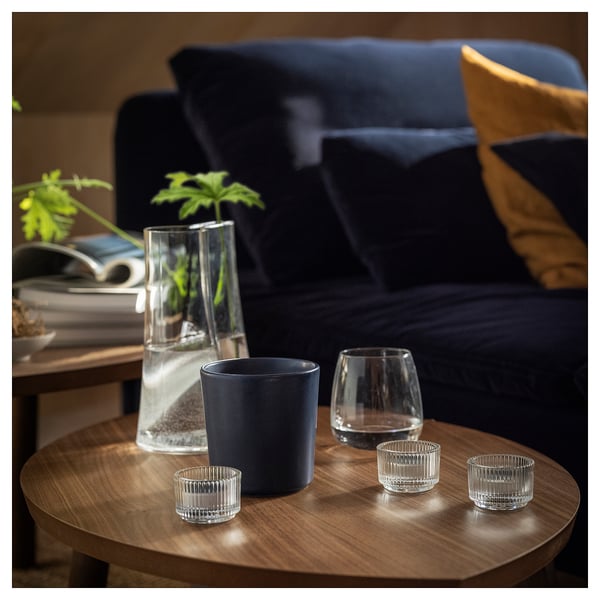 Cosy modern living room with blue couch, green vase, and candle.