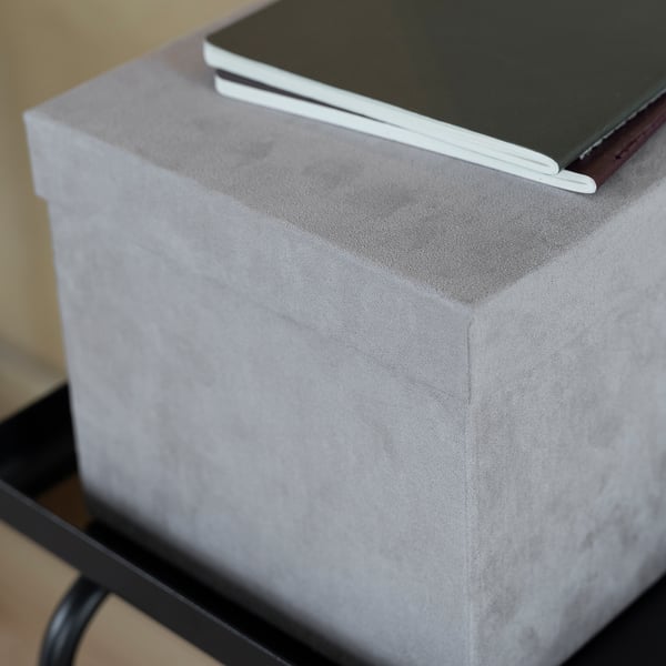 Grey velvet GJÄTTA box with black book on metal stand.