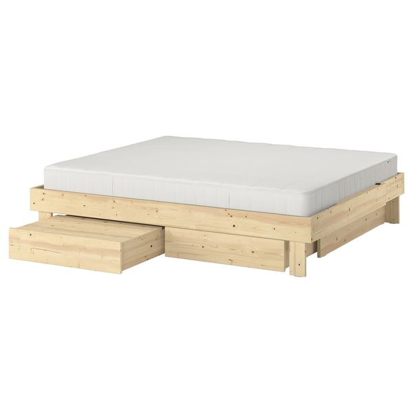 Wooden GLAMBERGET extendable bed with white mattress and storage boxes.