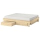 Wooden GLAMBERGET extendable bed with white mattress and storage boxes.