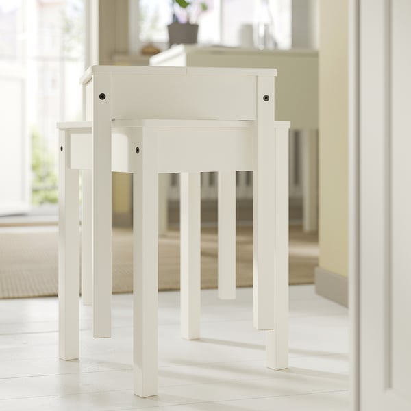 A white HAUGA stool made of solid pine with a simple design, suitable for extra seating or a side table.