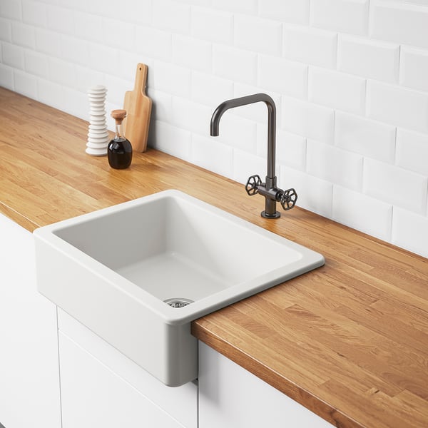 Modern kitchen with white HAVSEN sink, dark tap, cutting board, salt & pepper holder.