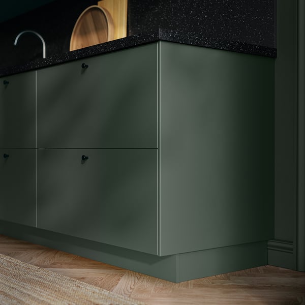 Dark green HAVSTORP kitchen cabinets with black speckled countertop.