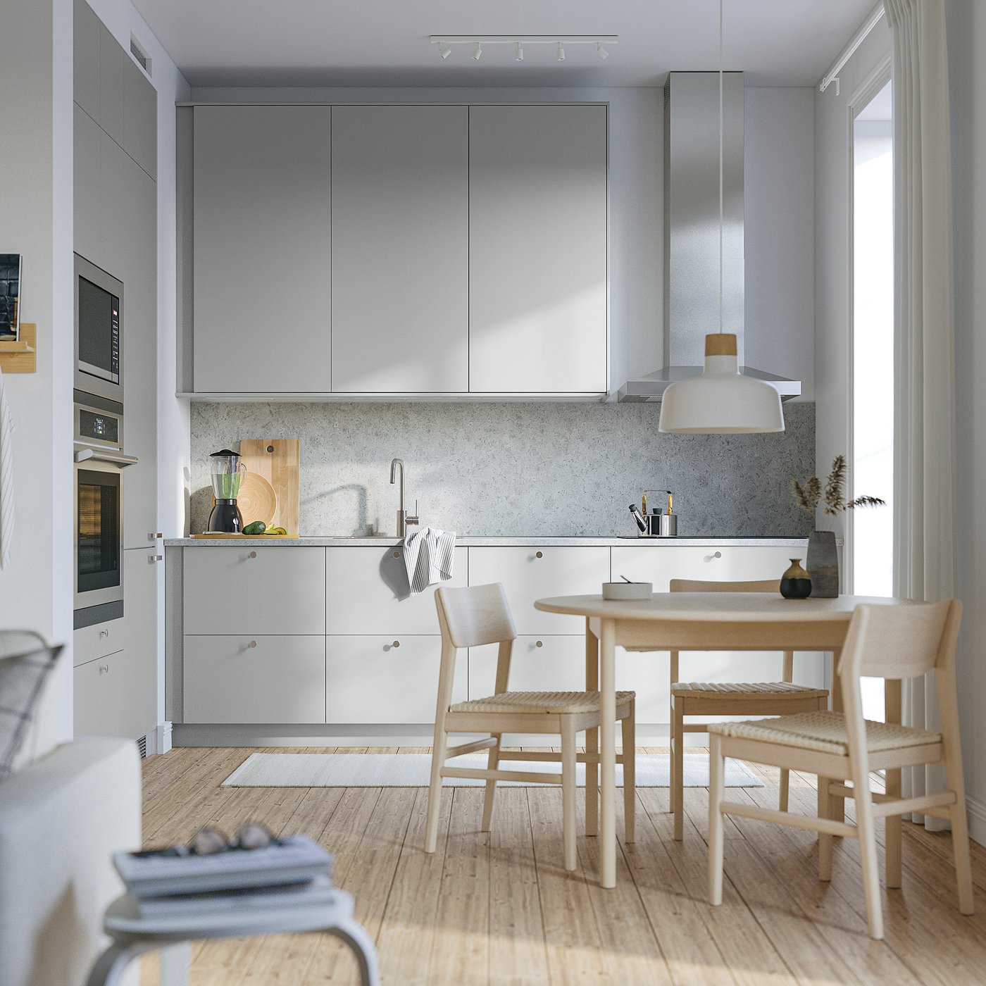 Modern kitchen with light grey HAVSTORP cabinets, smooth wood floor, round lightwood table, and minimalist design.
