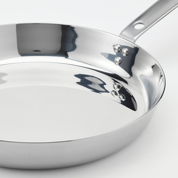 Polished stainless steel frying pan with chrome handle; elegant, durable, induction-ready; mirror finish inside.