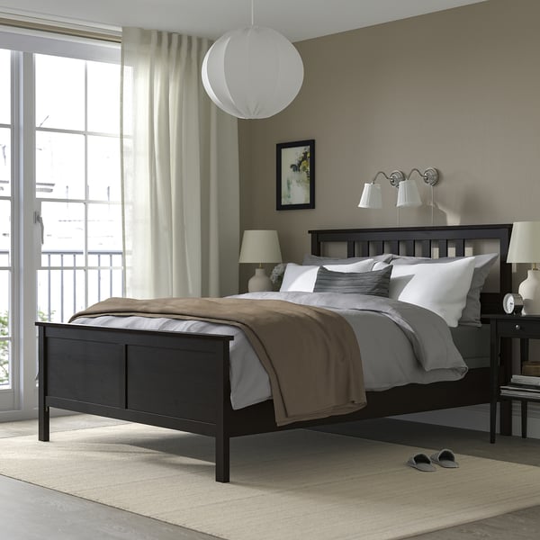 Black HEMNES bed with tall headboard, neutral pillows, soft window light.