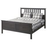 An ikea HEMNES bed in dark gray, featuring a solid wood frame, rectangular headboard, and checkered bedding.