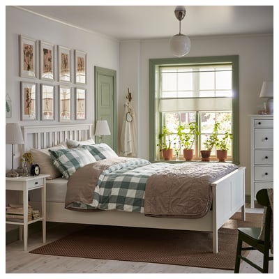 Cosy, bright bedroom with white HEMNES bed, green accents, checked bedspread, potted plants, and wall art.