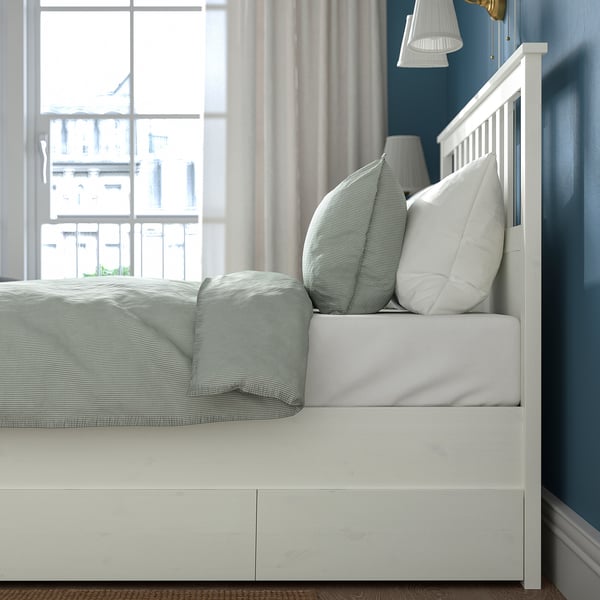 Bed with storage drawers, adjustable for mattress thickness, placed near a window.
