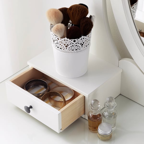 White vanity with open drawer showing jewellery boxes and ring holder, perfumes, and makeup brush holder on top.