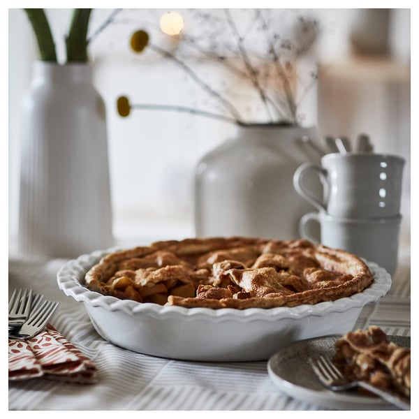 Apple pie in HÖSTAGILLE dish with mug and cutlery.
