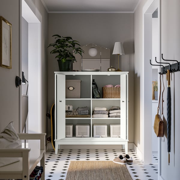 A modern storage cabinet in a stylish entryway, with folded doors and shelves for organised storage.