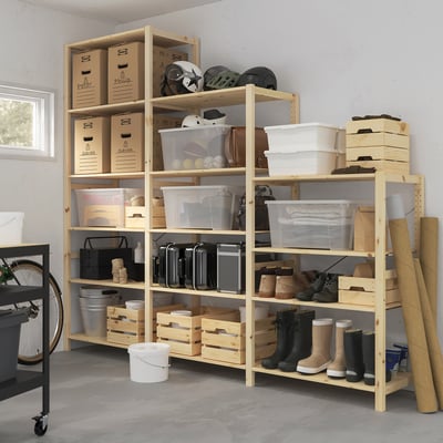 Wooden IVAR shelving unit with various storage bins and boots, standing larger than other items.