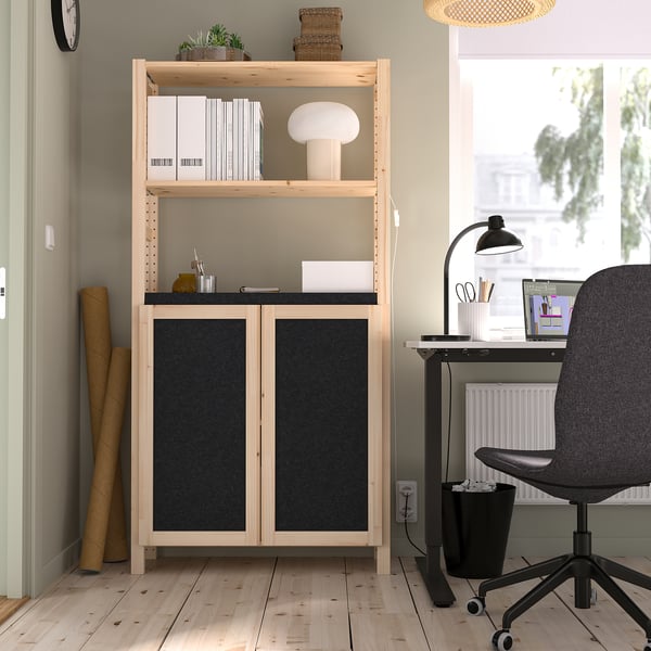 Home office with IVAR wood storage, shelves, and desk. Black office chair, lamp, and monroe desk. Light wooden floor.