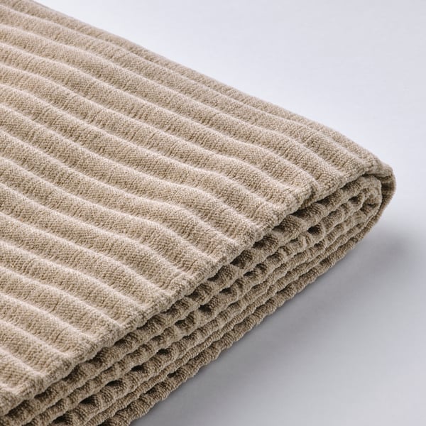 Folded beige textured fabric, likely a sofa cover, displayed neatly.