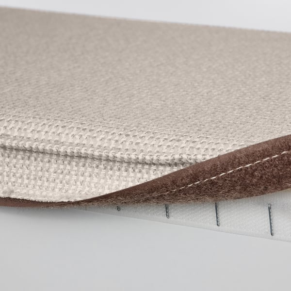 Close-up of KIVIK footstools two-tone beige fabric. Soft, textured cover with stitching and white underside.