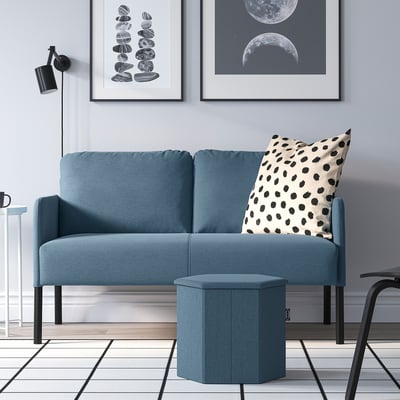Blue KJUGE 2-seater sofa with polka dot pillow near wall art in modern living room.