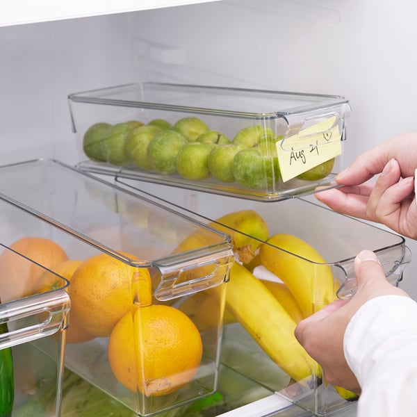 Person grabbing a fridge container holding fruits and labelled aug 21.